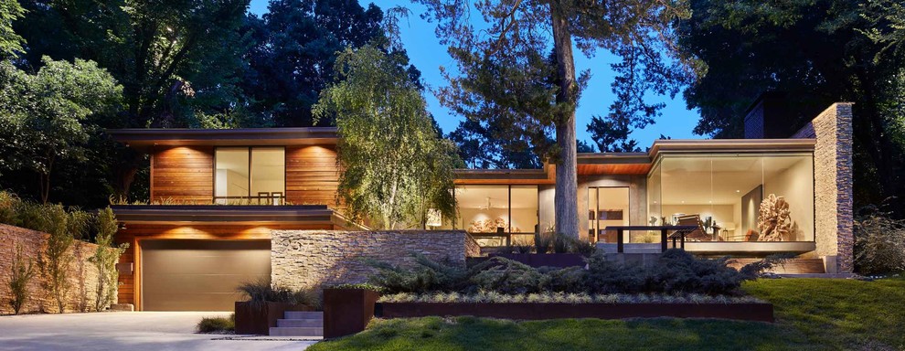 Diseño de fachada de casa marrón minimalista grande a niveles con revestimiento de madera, tejado plano y tejado de varios materiales