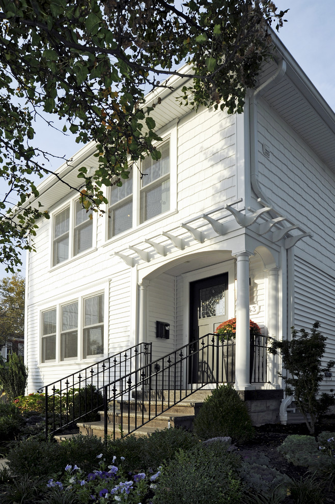 Exemple d'une petite façade de maison blanche chic en bois à un étage avec un toit à quatre pans.
