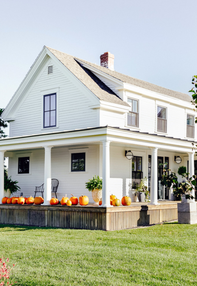 Ejemplo de fachada de casa blanca de estilo de casa de campo de dos plantas con revestimiento de madera y tejado de varios materiales