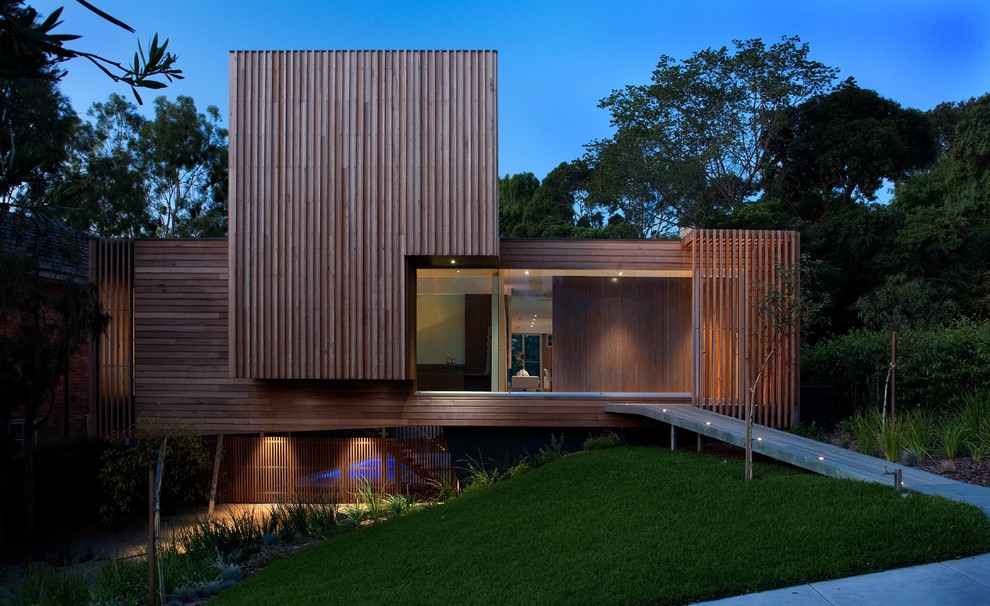 Ejemplo de fachada marrón contemporánea de tamaño medio de dos plantas con revestimiento de madera y tejado plano