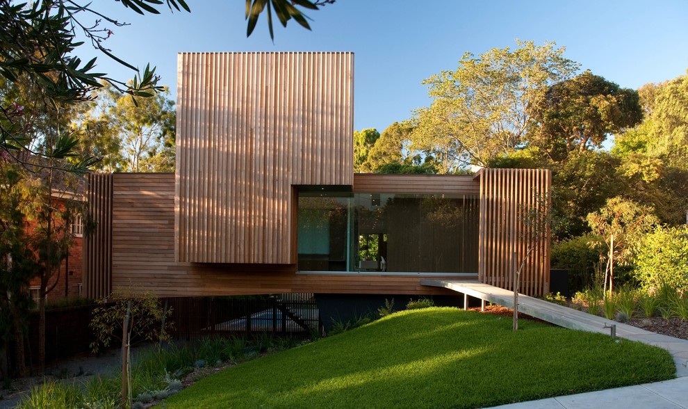 Idées déco pour une façade de maison marron contemporaine en bois de taille moyenne et à un étage avec un toit plat.