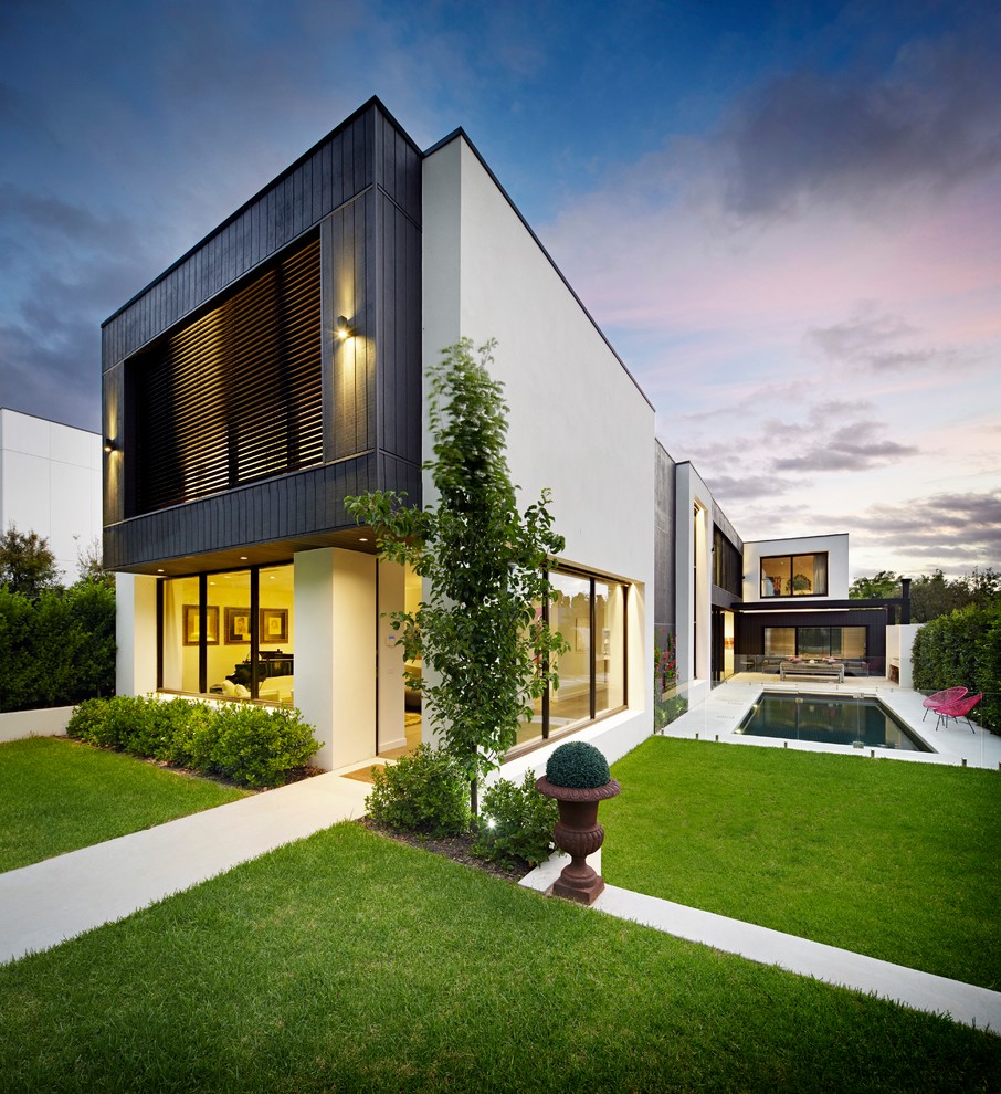 Réalisation d'une façade de maison blanche minimaliste en verre à un étage avec un toit plat.
