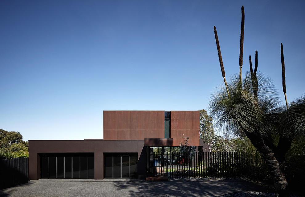 Photo of a large contemporary house exterior in Melbourne with three floors and metal cladding.