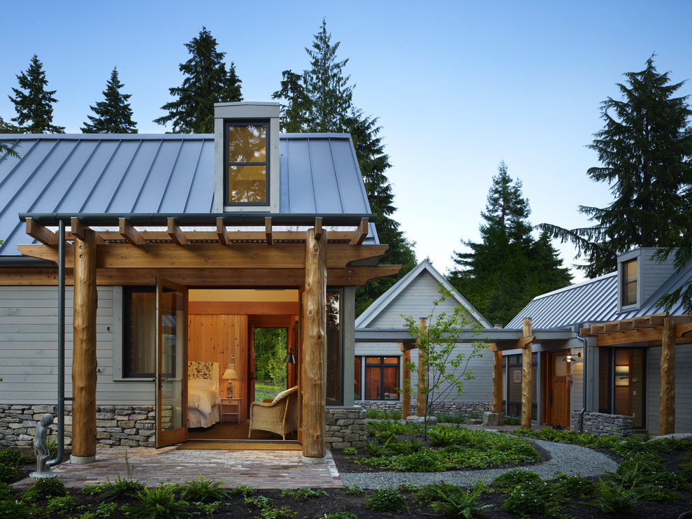Medium sized rustic bungalow house exterior in Seattle with wood cladding and a pitched roof.