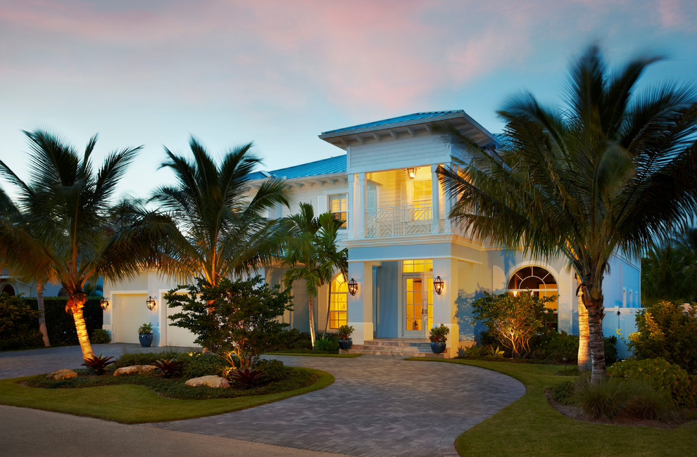 Foto de fachada azul tropical grande de dos plantas con revestimientos combinados y tejado a cuatro aguas