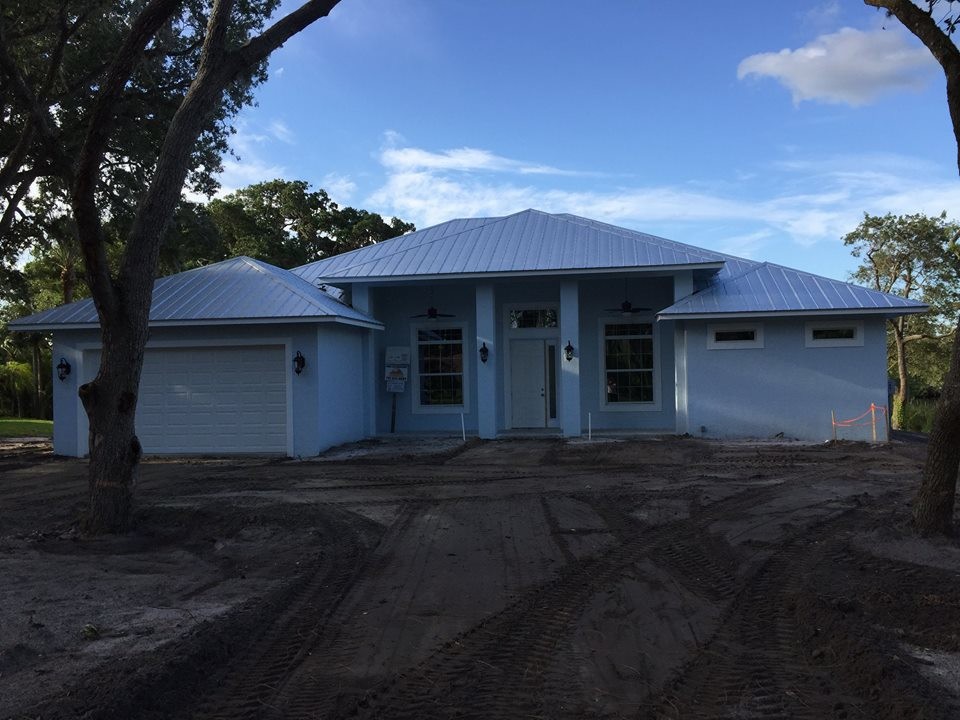 Bild på ett mellanstort tropiskt blått hus, med allt i ett plan och stuckatur