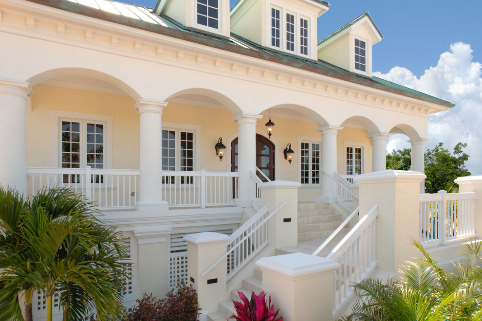 Großes, Zweistöckiges Einfamilienhaus mit Putzfassade, gelber Fassadenfarbe und Blechdach in Miami