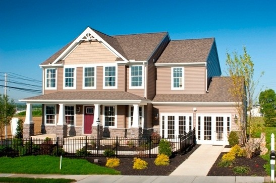 На фото: двухэтажный, коричневый дом среднего размера в классическом стиле с облицовкой из камня и вальмовой крышей с