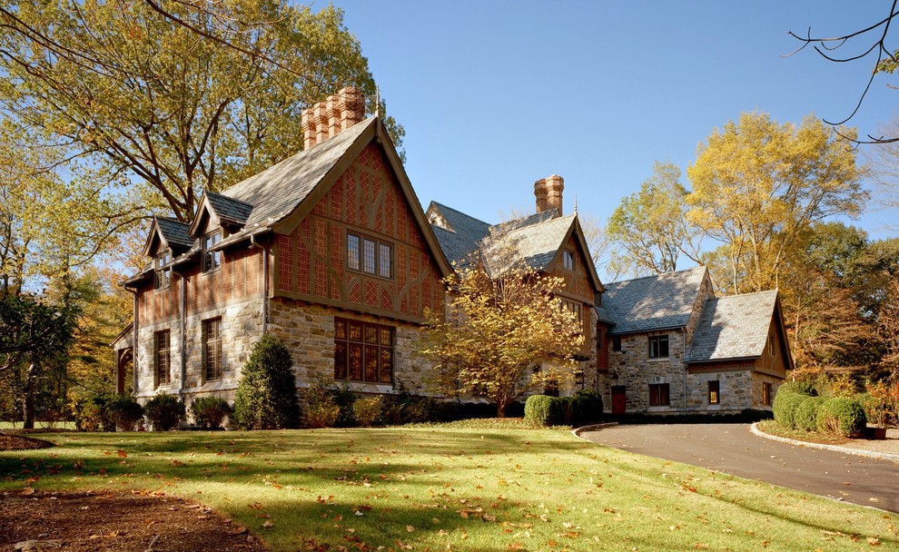 Foto della villa grande marrone american style a due piani con rivestimenti misti, tetto a capanna e copertura a scandole