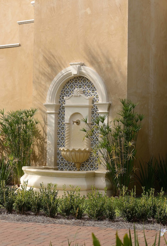 На фото: большой, двухэтажный, бежевый частный загородный дом в средиземноморском стиле с облицовкой из цементной штукатурки с