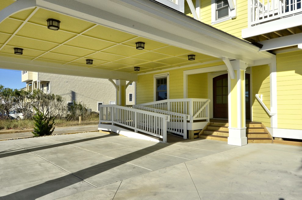 Стильный дизайн: трехэтажный, желтый дом среднего размера в морском стиле с облицовкой из винила и двускатной крышей - последний тренд