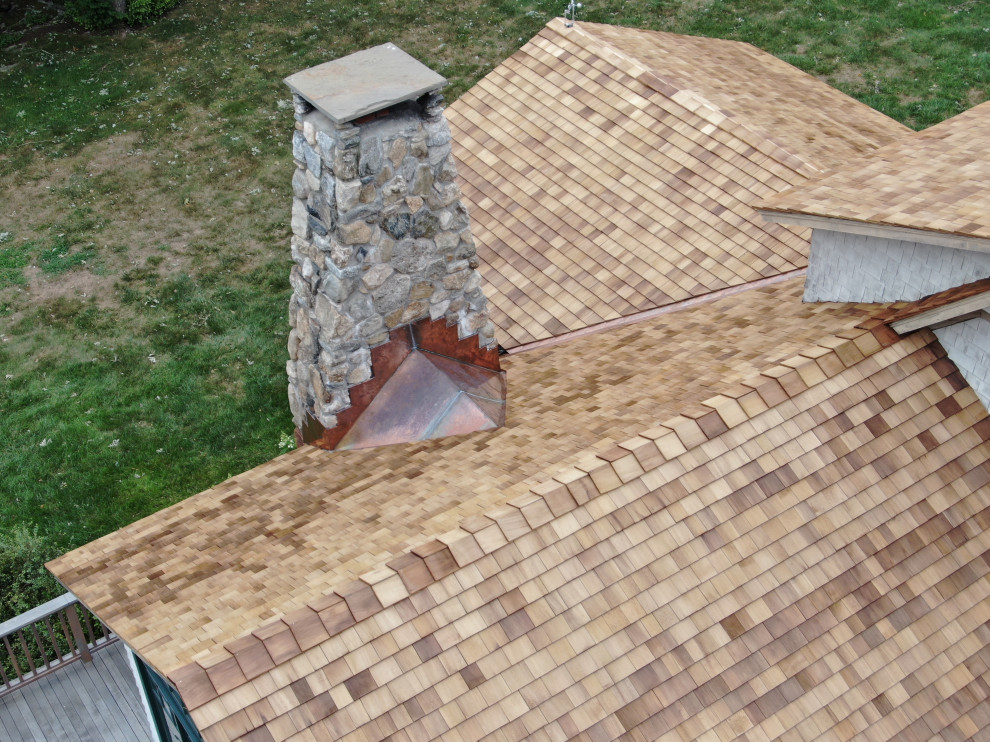 Cette photo montre une grande façade de maison beige nature en bois à deux étages et plus avec un toit à deux pans et un toit en shingle.