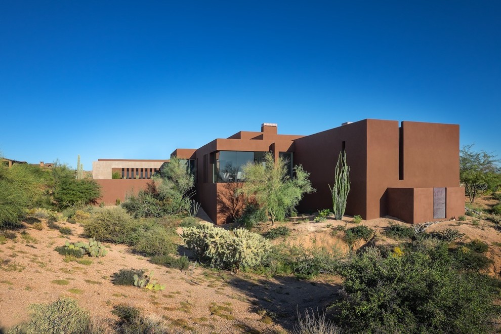 Imagen de fachada de casa marrón de estilo americano de tamaño medio de dos plantas con revestimiento de estuco, tejado plano y techo verde