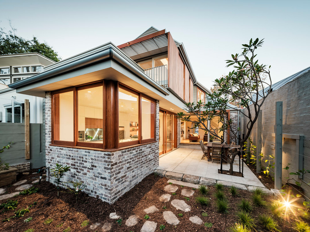 Cette photo montre une façade de maison beige tendance en bois à un étage et de taille moyenne avec un toit en métal et un toit à quatre pans.