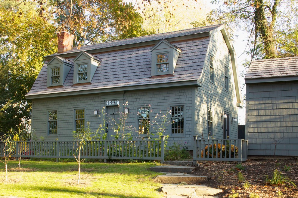 Diseño de fachada gris de estilo de casa de campo con revestimiento de madera y tejado a doble faldón