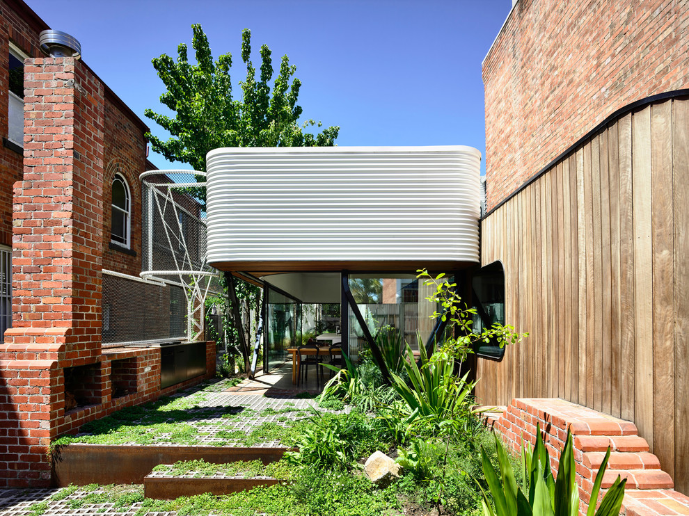 Diseño de fachada de casa moderna de dos plantas con revestimiento de metal, tejado de un solo tendido y tejado de metal