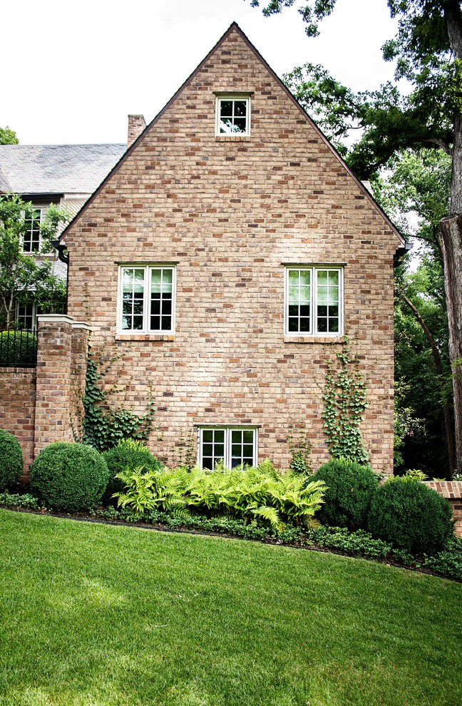 Inspiration for a large timeless brown two-story brick exterior home remodel in Other with a shingle roof