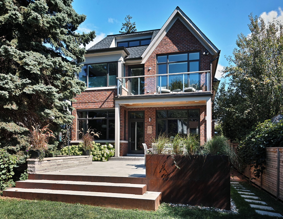 Example of a mid-sized transitional red two-story brick exterior home design in Toronto with a shingle roof