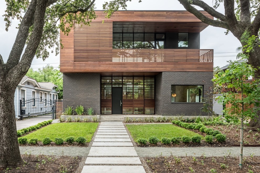 Zweistöckiges, Großes Modernes Haus mit Mix-Fassade, Flachdach und schwarzer Fassadenfarbe in Houston