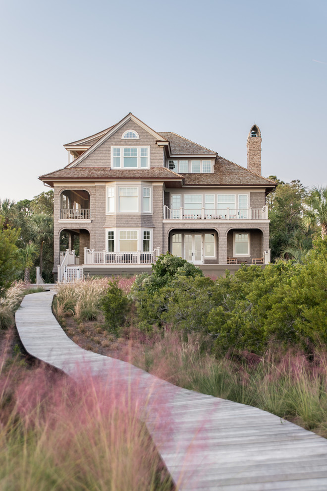 Example of a beach style three-story wood house exterior design in Charleston with a shingle roof