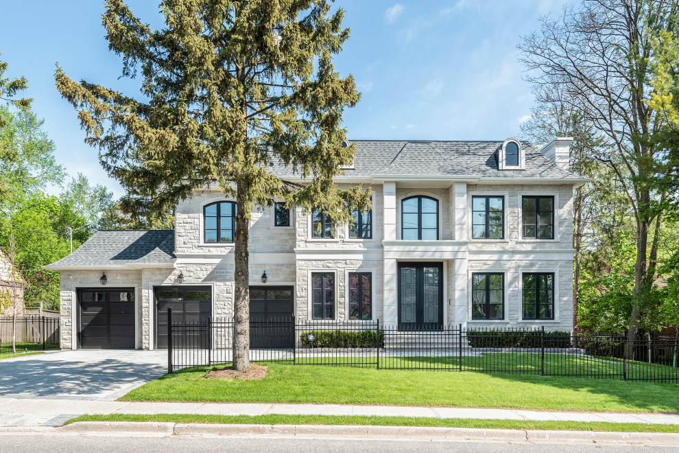Large transitional white two-story stone house exterior photo in Toronto with a hip roof and a shingle roof