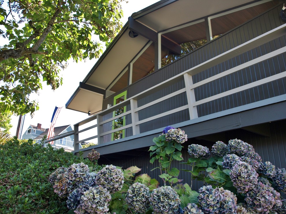 Cette image montre une façade de maison marron vintage en bois de taille moyenne et de plain-pied avec un toit à deux pans.