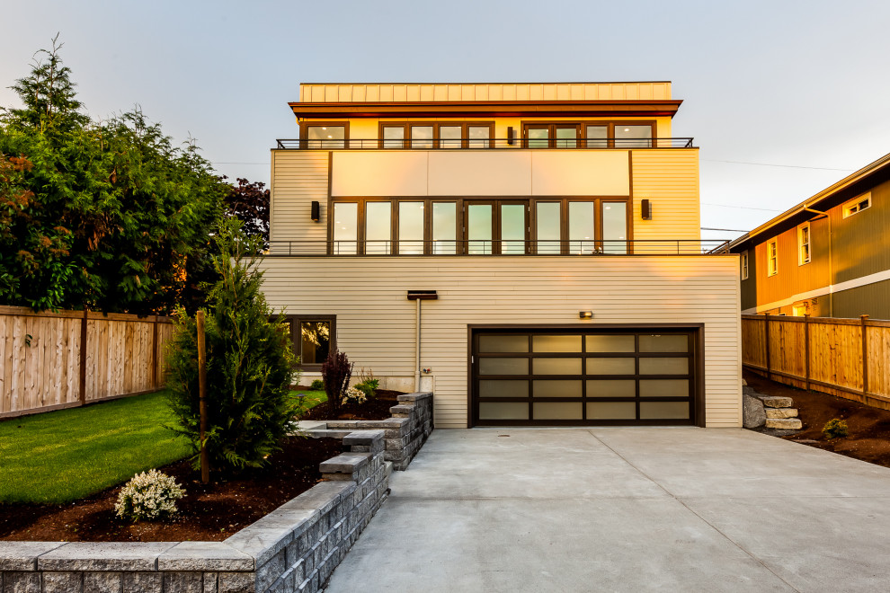 Photo of a large and beige contemporary detached house in Seattle with three floors, concrete fibreboard cladding and a flat roof.