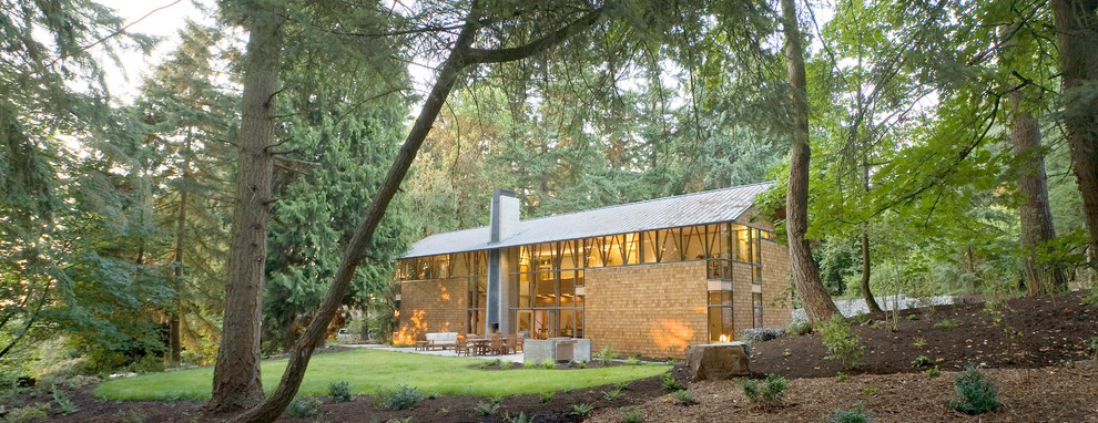 Großes, Zweistöckiges Industrial Einfamilienhaus mit Glasfassade, brauner Fassadenfarbe, Satteldach und Blechdach in Seattle