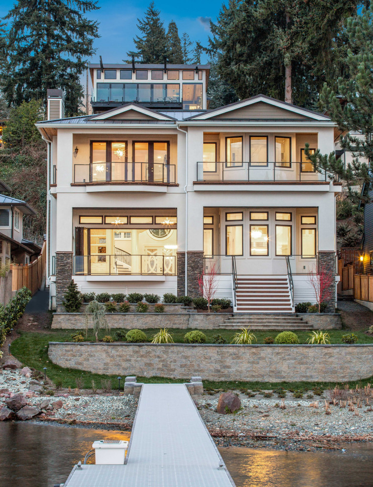 Photo of a white traditional detached house in Seattle with three floors, a hip roof and a metal roof.