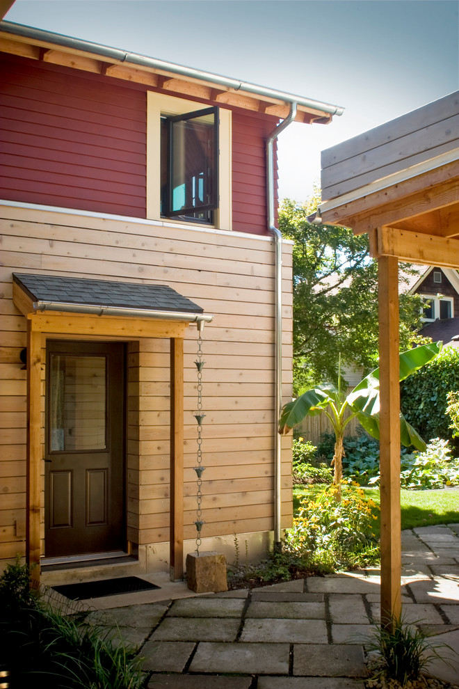 Inspiration pour une façade de maison rouge design en bois à un étage.
