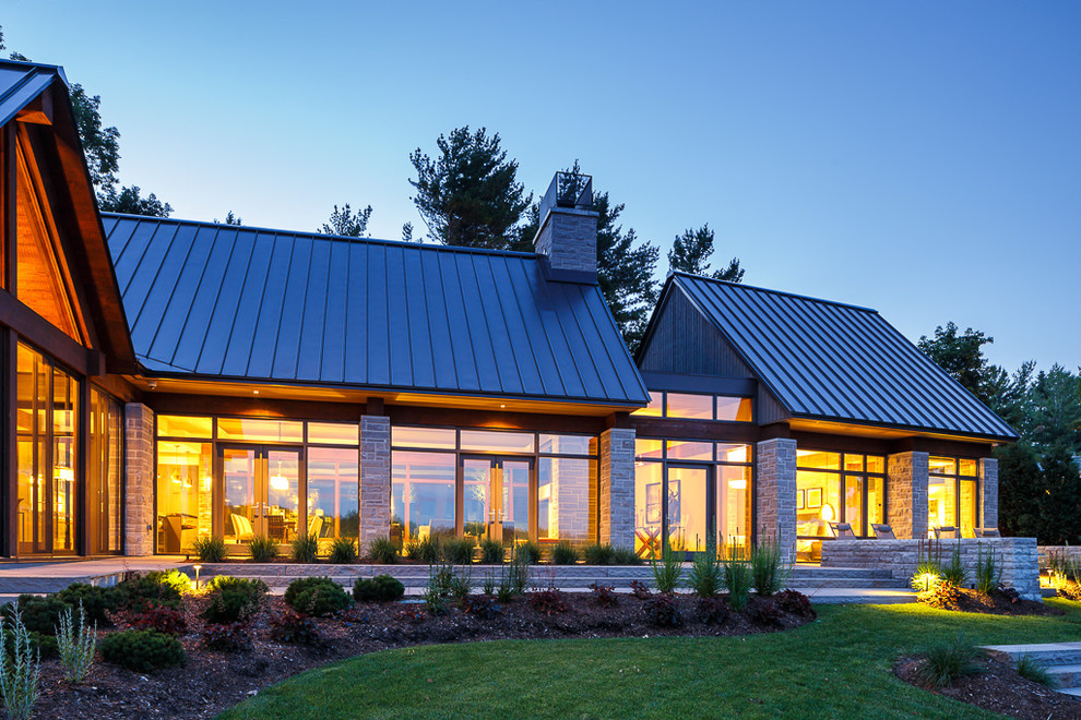 Источник вдохновения для домашнего уюта: большой, двухэтажный, серый частный загородный дом в современном стиле с облицовкой из камня, двускатной крышей и металлической крышей