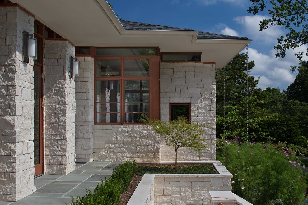 Ejemplo de fachada de casa multicolor de estilo americano extra grande de una planta con revestimiento de piedra, tejado a dos aguas y tejado de teja de madera