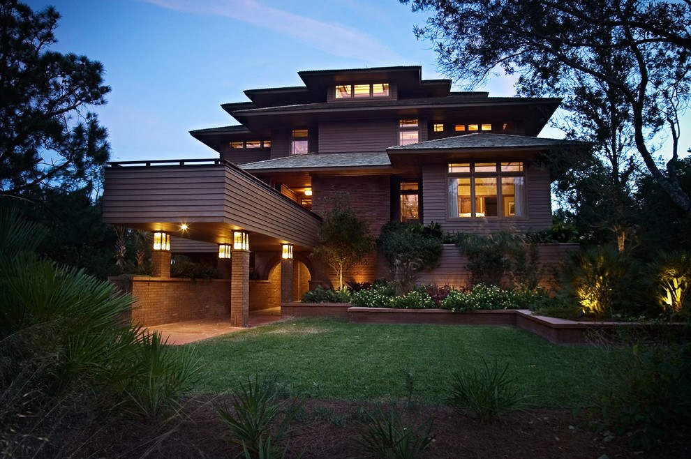 This is an example of a large and brown world-inspired detached house in Charleston with three floors, wood cladding, a hip roof and a shingle roof.