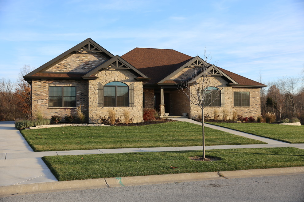 Brown and medium sized rustic bungalow house exterior in Chicago with stone cladding and a hip roof.