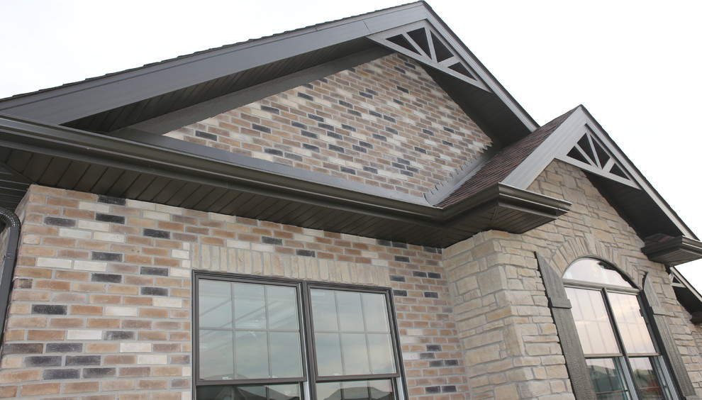 Example of a mid-sized mountain style brown one-story stone exterior home design in Chicago with a hip roof