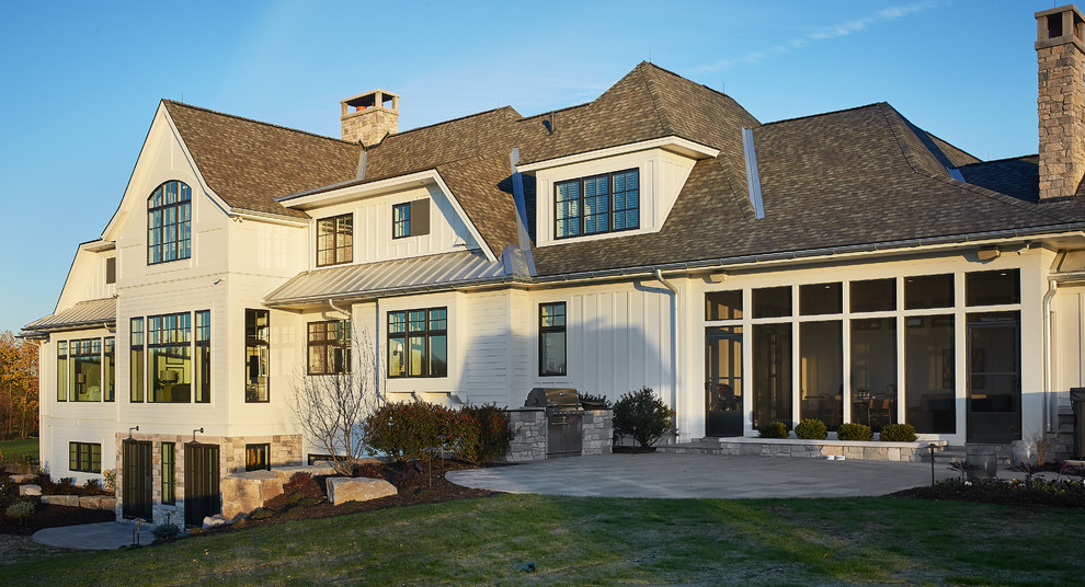 Imagen de fachada de casa beige campestre extra grande de dos plantas con revestimientos combinados, tejado a cuatro aguas y tejado de teja de madera