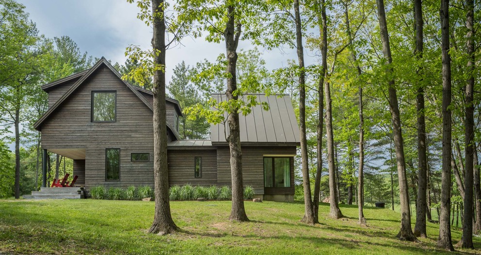 Стильный дизайн: деревянный, коричневый, двухэтажный частный загородный дом среднего размера в современном стиле с двускатной крышей и металлической крышей - последний тренд