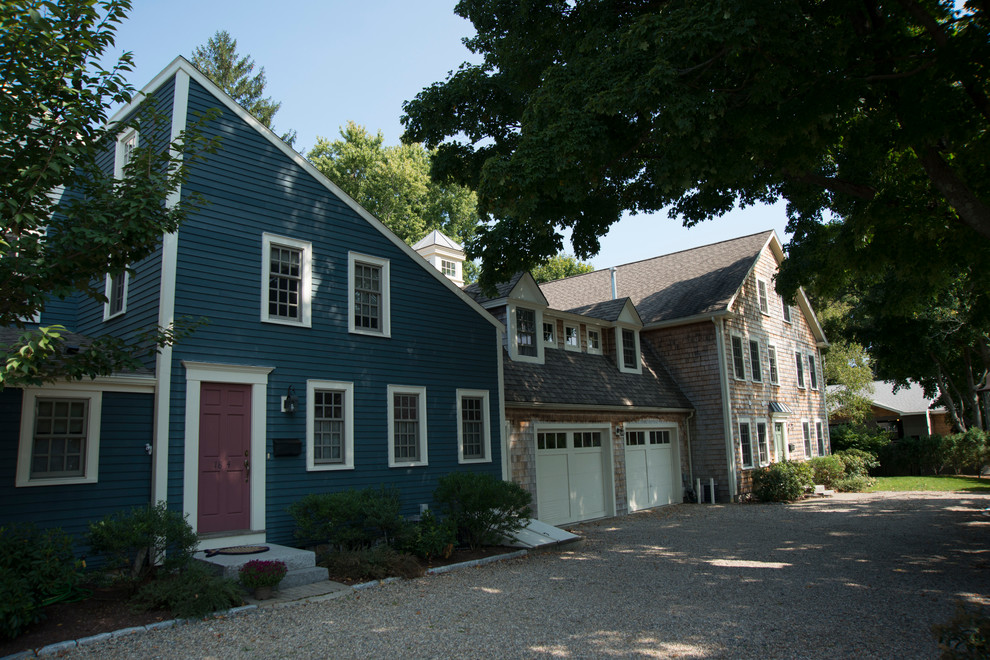 Esempio della casa con tetto a falda unica grande blu classico a due piani con rivestimento in legno