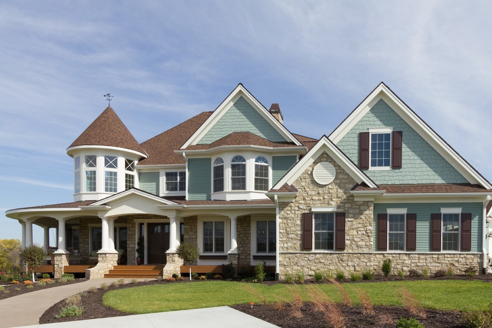 Exemple d'une grande façade de maison multicolore chic à un étage avec un revêtement mixte et un toit à quatre pans.