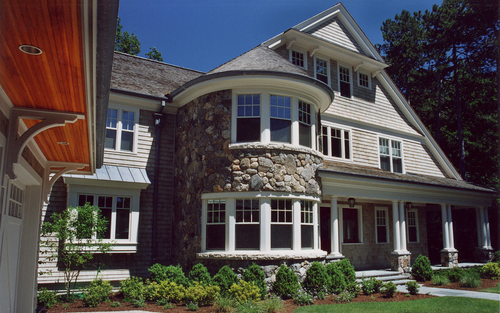 Aménagement d'une grande façade de maison classique en pierre à deux étages et plus.
