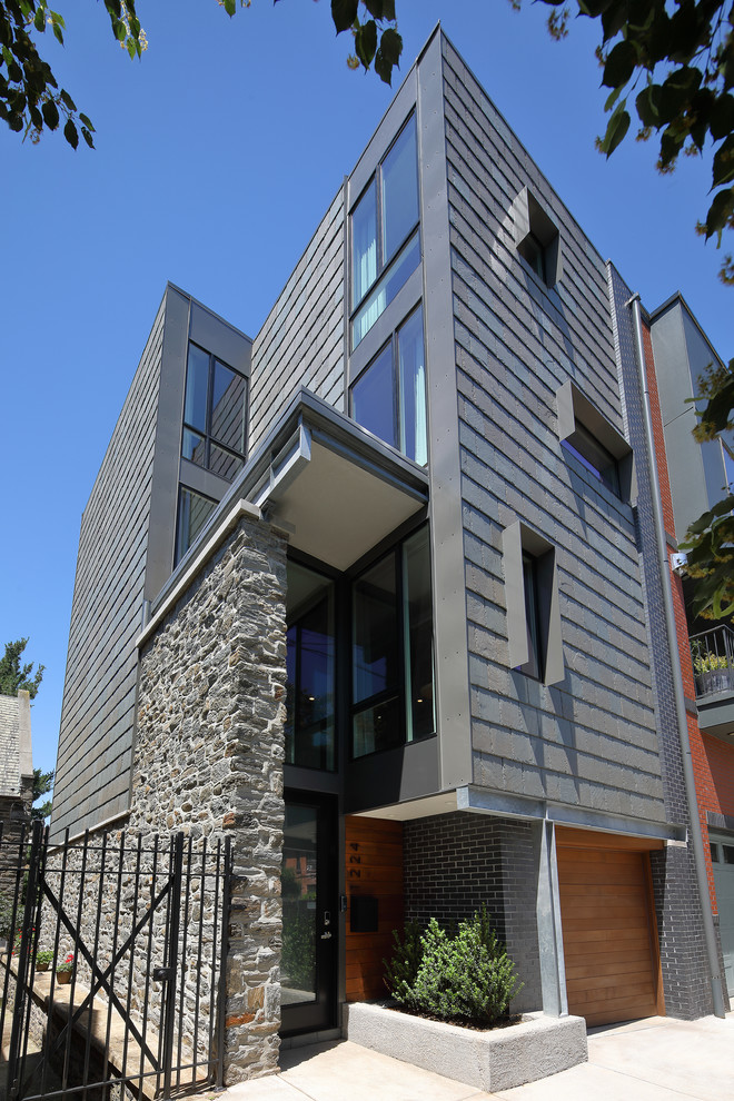 Large and gey modern terraced house in Philadelphia with three floors, stone cladding, a flat roof and a mixed material roof.