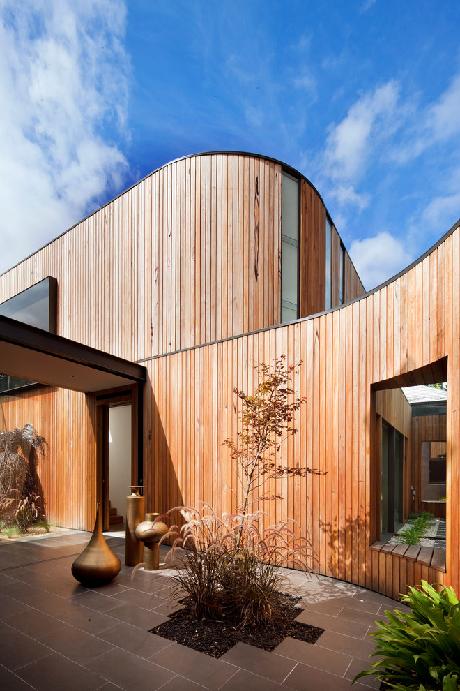 Свежая идея для дизайна: огромный, двухэтажный, деревянный, коричневый дом в современном стиле с плоской крышей - отличное фото интерьера