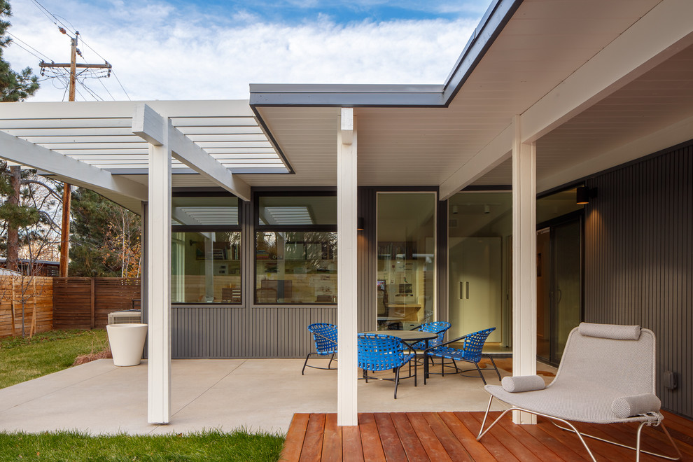 Diseño de fachada gris retro de tamaño medio de una planta con revestimiento de madera y tejado plano