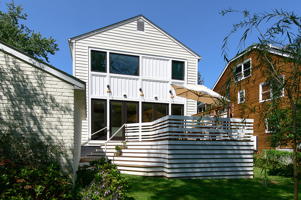 Стильный дизайн: двухэтажный, белый частный загородный дом в морском стиле с облицовкой из ЦСП, двускатной крышей и крышей из гибкой черепицы - последний тренд