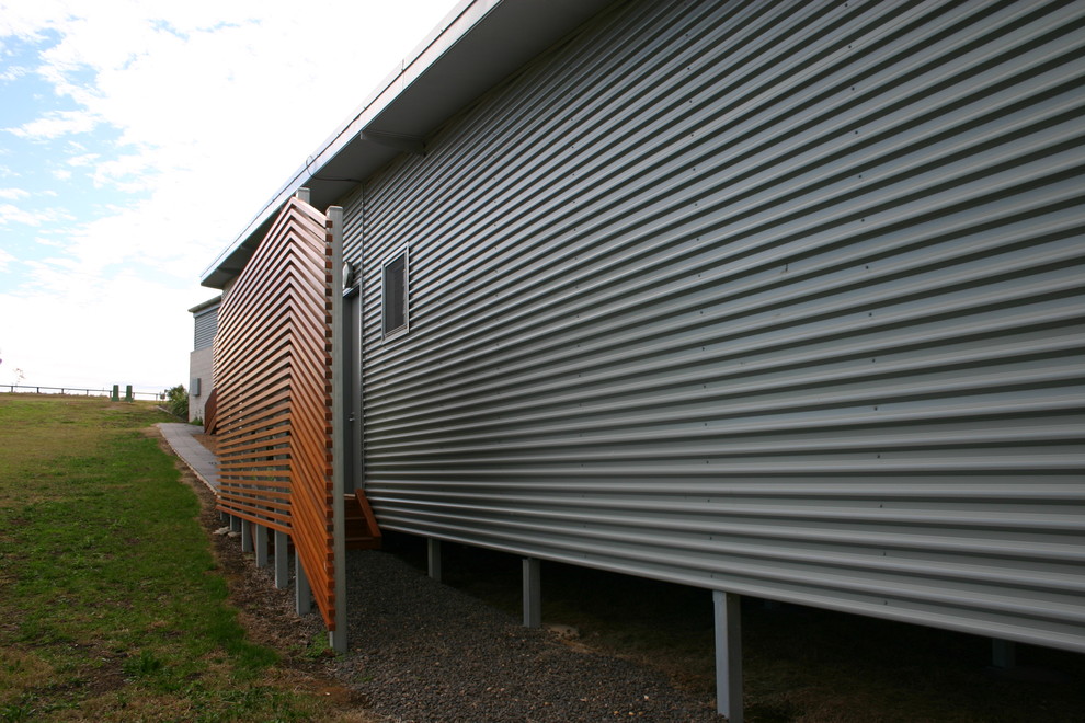 Immagine della villa grigia industriale a piani sfalsati di medie dimensioni con rivestimento in metallo