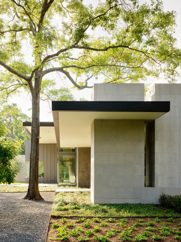 Idée de décoration pour une façade de maison grise design en pierre avec un toit plat.