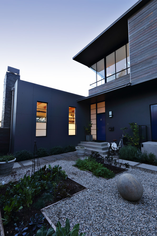 Foto de fachada de casa azul urbana de tamaño medio de dos plantas con revestimiento de estuco, tejado plano y tejado de metal