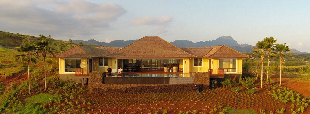 Photo of a yellow world-inspired bungalow house exterior in Hawaii.