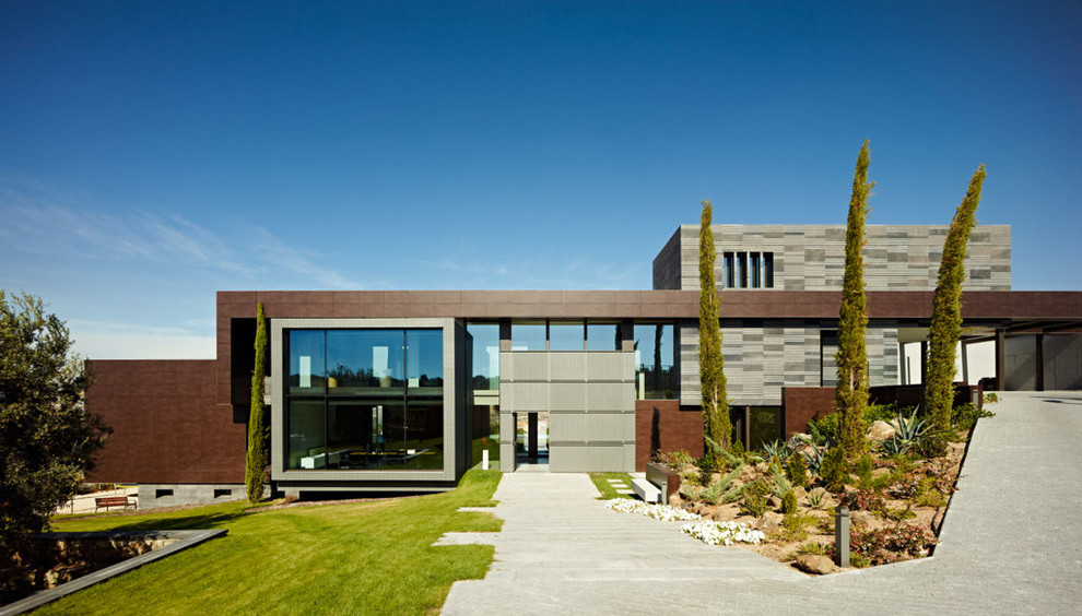 Diseño de fachada gris actual grande de tres plantas con revestimientos combinados y tejado plano