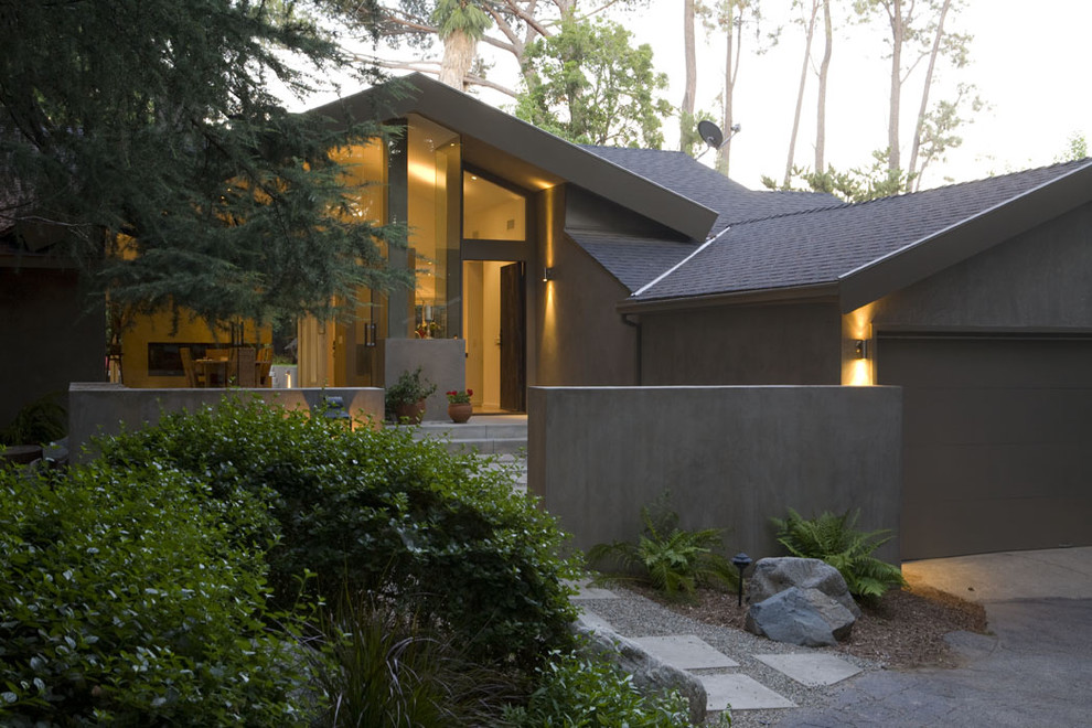 Inspiration pour une grande façade de maison grise design en stuc de plain-pied avec un toit à croupette.